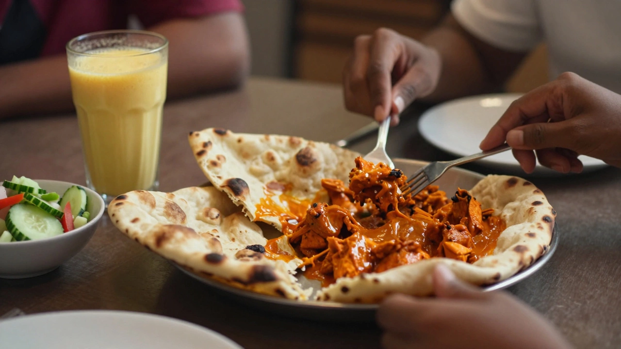 Shared dish of chicken tikka masala with naan and cucumber salad at a cozy dining table.